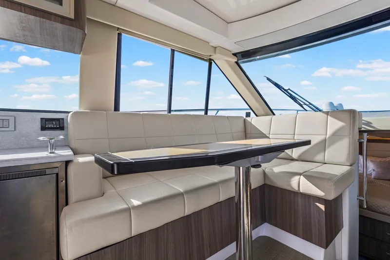 Slide: The Image of Luxurious interior of 2020 Regal 38 XO yacht with plush seating and panoramic windows. - 14