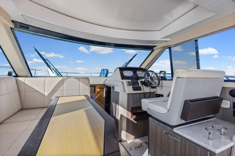 Slide: The Image of Interior of 2020 Regal 38 XO yacht with modern helm and seating under blue sky. - 16