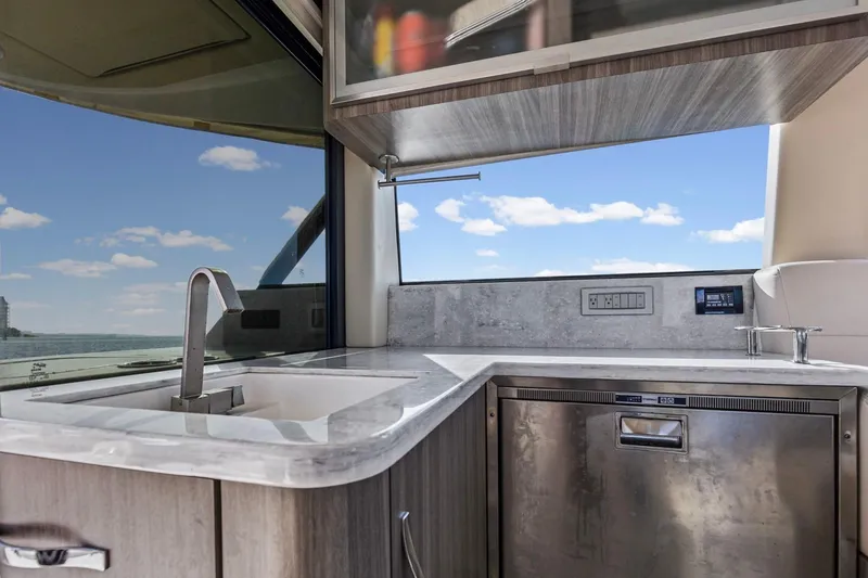 Slide: The Image of Modern kitchen area on 2020 Regal 38 XO yacht with sleek design and ocean view. - 19