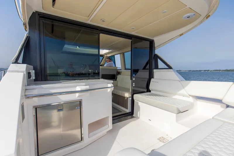 Slide: The Image of 2020 Regal 38 XO yacht interior with seating and sliding glass door, overlooking the water. - 22