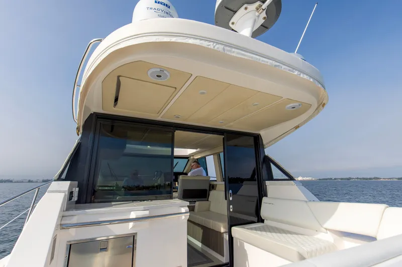 Slide: The Image of 2020 Regal 38 XO yacht with sleek design, spacious deck, and modern amenities on open water. - 25