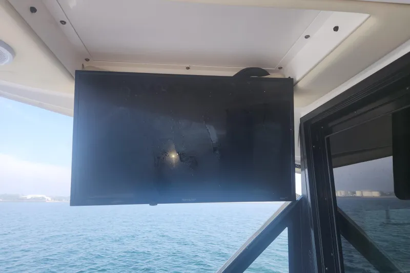 Slide: The Image of Flat-screen TV on 2020 Regal 38 XO yacht, overlooking calm ocean waters. - 27