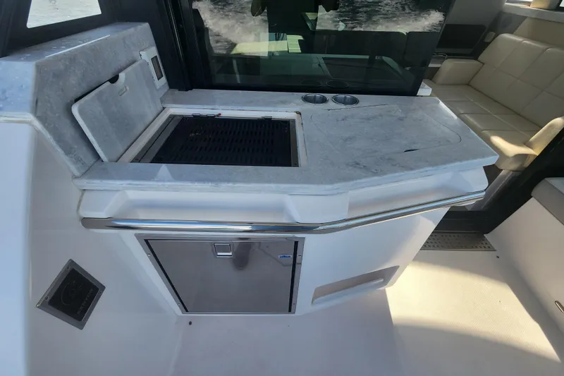 Slide: The Image of Outdoor kitchen area on a 2020 Regal 38 XO yacht with grill and seating. - 28