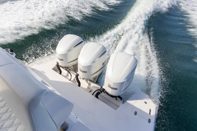 Slide: The Image of 2020 Regal 38 XO boat with triple outboard engines cruising on water. - 40