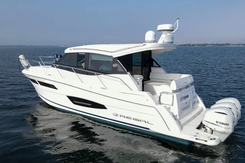 Slide: The Image of 2020 Regal 38 XO yacht cruising on open water with Yamaha engines. - 5
