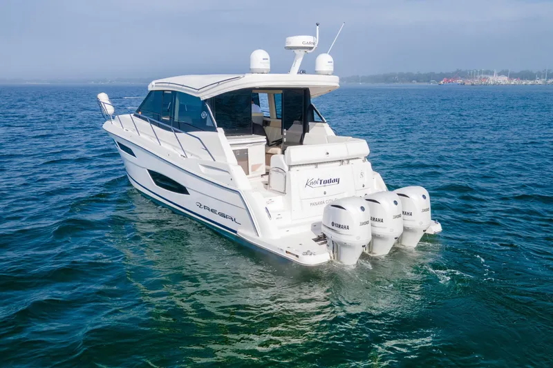 Slide: The Image of 2020 Regal 38 XO boat cruising on open water with Yamaha engines. - 7