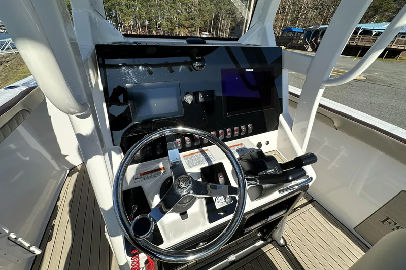 Slide: The Image of 2023 Yamaha Boats 252 FSH Sport helm with steering wheel and control panel. - 16