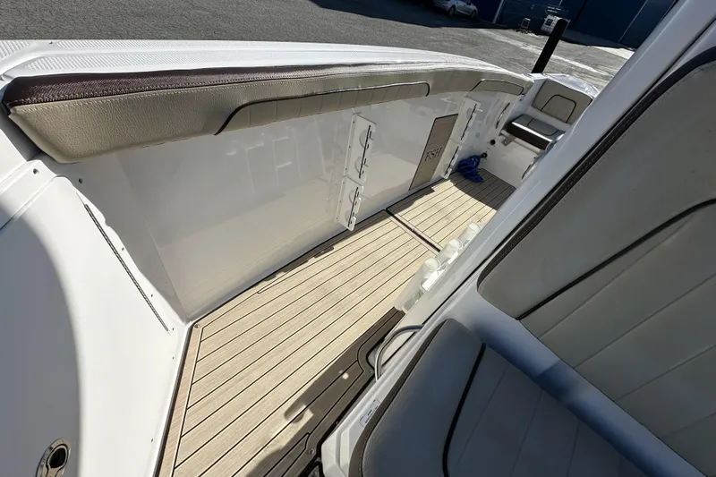 Slide: The Image of 2023 Yamaha Boats 252 FSH Sport interior with sleek seating and wood-style flooring. - 22