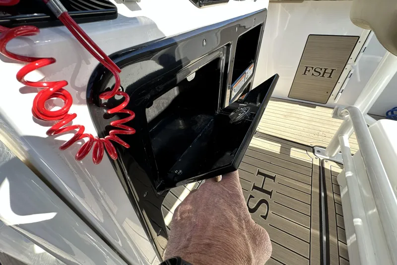 Slide: The Image of 2023 Yamaha Boats 252 FSH Sport interior with storage compartment and safety cord. - 30
