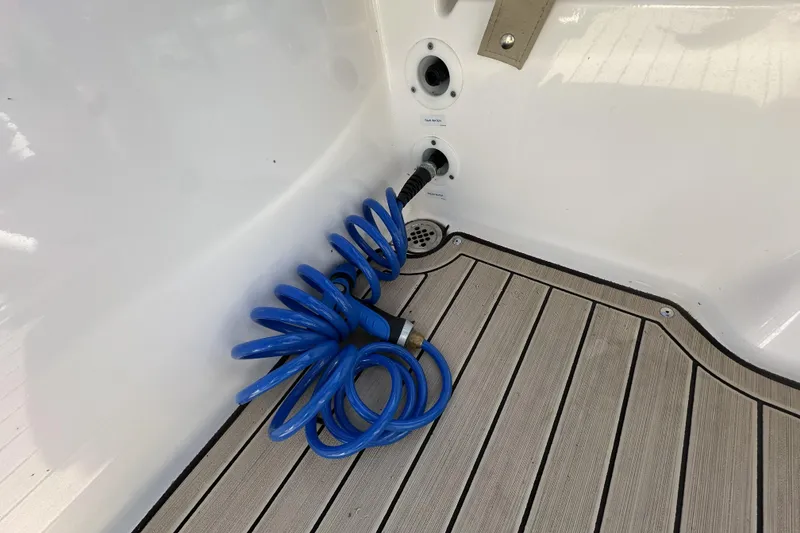 Slide: The Image of 2023 Yamaha Boats 252 FSH Sport deck with coiled blue hose and drainage system. - 31