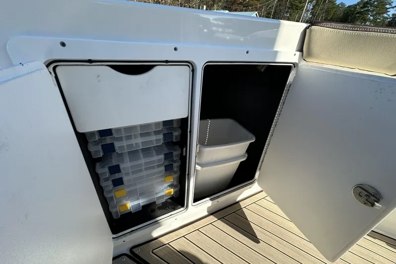 Slide: The Image of Storage compartments on a 2023 Yamaha Boats 252 FSH Sport, featuring organized tackle boxes. - 32