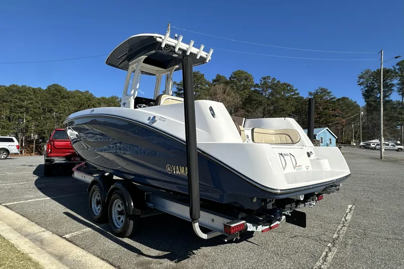 Slide: The Image of 2023 Yamaha Boats 252 FSH Sport on trailer, parked outdoors under clear blue sky. - 6