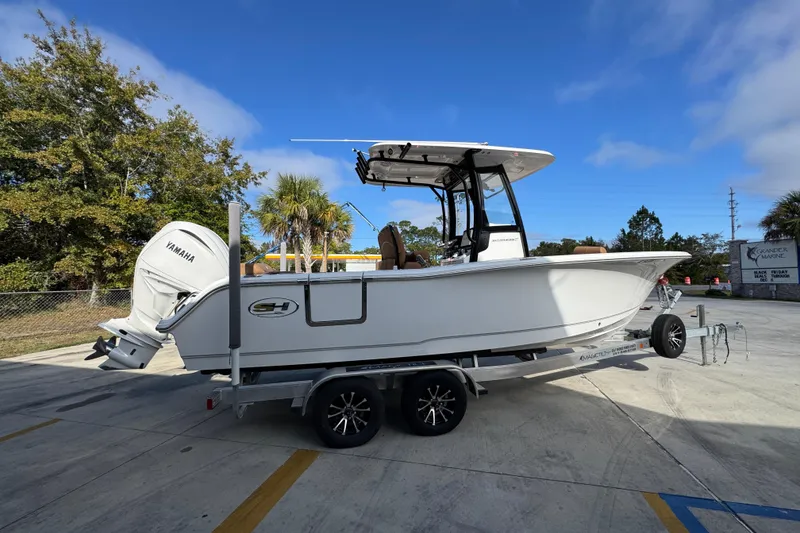 Slide: The Image of 2024 Sea Hunt Ultra 239 SE boat on trailer, parked outdoors under clear sky. - 10