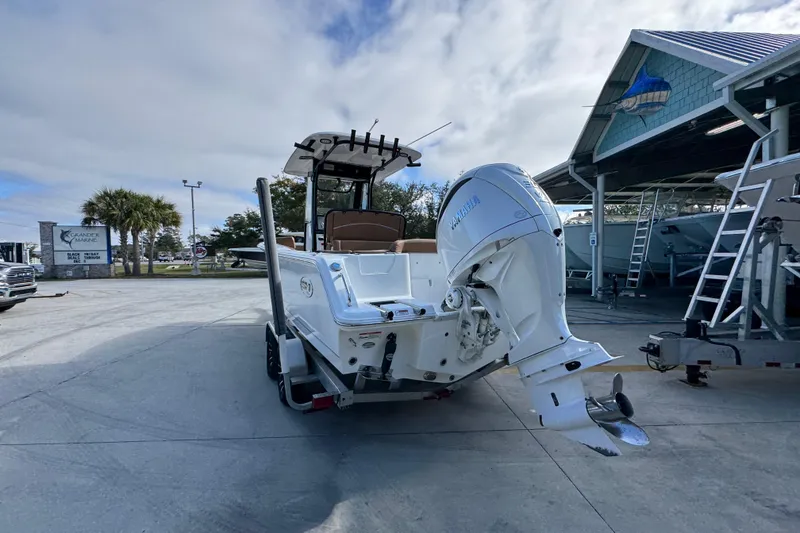 Slide: The Image of 2024 Sea Hunt Ultra 239 SE boat with Yamaha outboard motor, parked outdoors. - 13