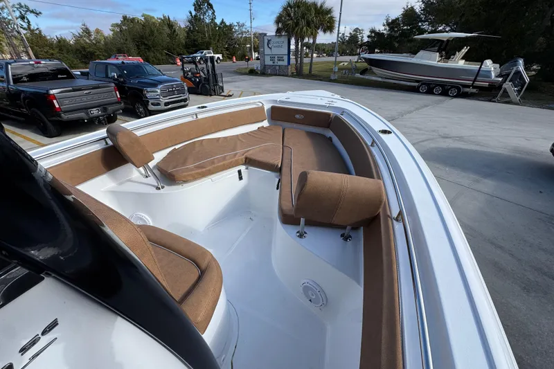 Slide: The Image of 2024 Sea Hunt Ultra 239 SE boat with tan seating, parked outdoors. - 16
