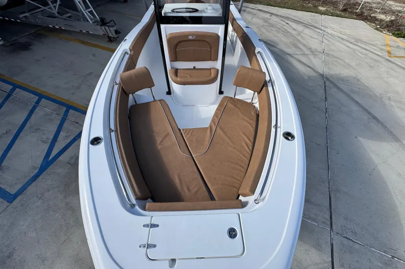 Slide: The Image of 2024 Sea Hunt Ultra 239 SE boat with tan seating, docked on concrete. - 19