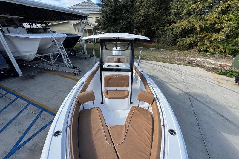 Slide: The Image of 2024 Sea Hunt Ultra 239 SE boat with tan seating, docked outdoors. - 20