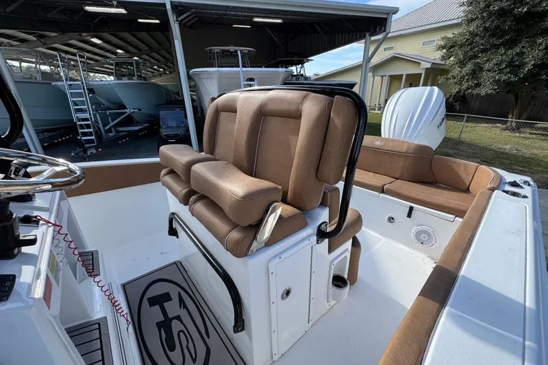 Slide: The Image of 2024 Sea Hunt Ultra 239 SE boat interior with brown seating and steering wheel. - 24