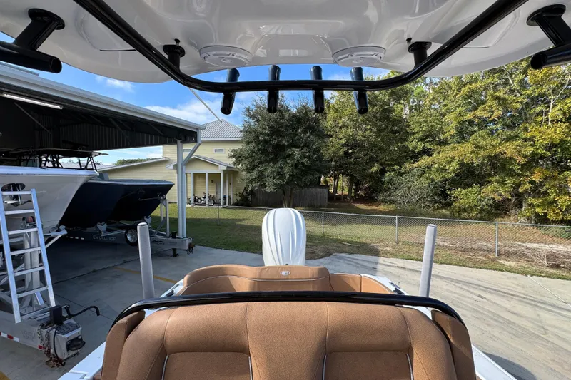 Slide: The Image of 2024 Sea Hunt Ultra 239 SE boat interior with brown seating and overhead rod holders. - 26