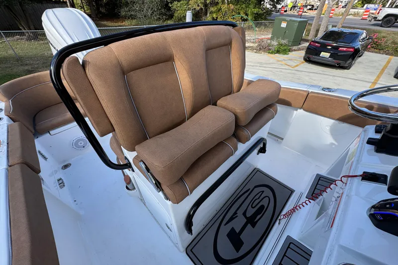 Slide: The Image of 2024 Sea Hunt Ultra 239 SE boat with tan cushioned seating and steering console. - 31