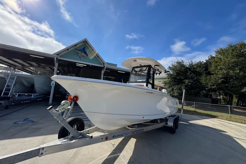 Slide: The Image of 2024 Sea Hunt Ultra 239 SE boat on trailer under clear blue sky. - 4