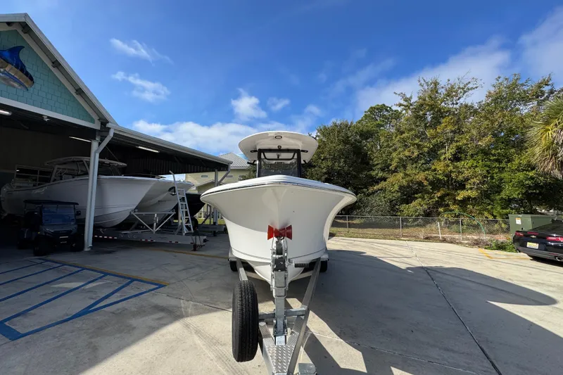 Slide: The Image of 2024 Sea Hunt Ultra 239 SE boat on trailer, parked outdoors near a building. - 6