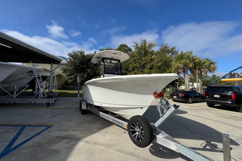 Slide: The Image of 2024 Sea Hunt Ultra 239 SE boat on trailer in sunny outdoor setting. - 7