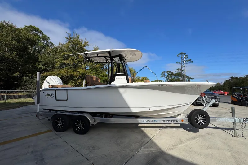 Slide: The Image of 2024 Sea Hunt Ultra 239 SE boat on trailer, parked outdoors under clear blue sky. - 9