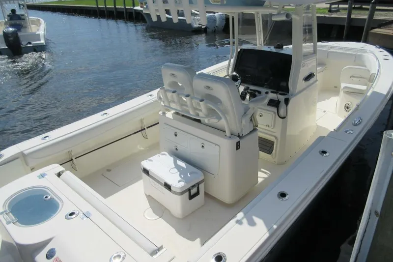 Slide: The Image of 2020 Cobia 280 Center Console boat docked, featuring spacious seating and modern controls. - 3