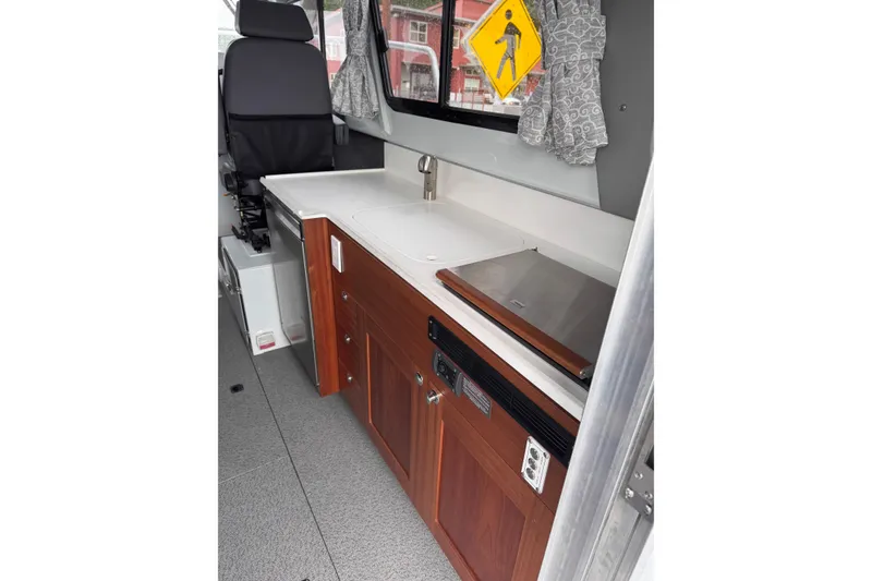 Slide: The Image of Interior of 2026 Hewescraft 290 Adventure boat with kitchenette and seating. - 10