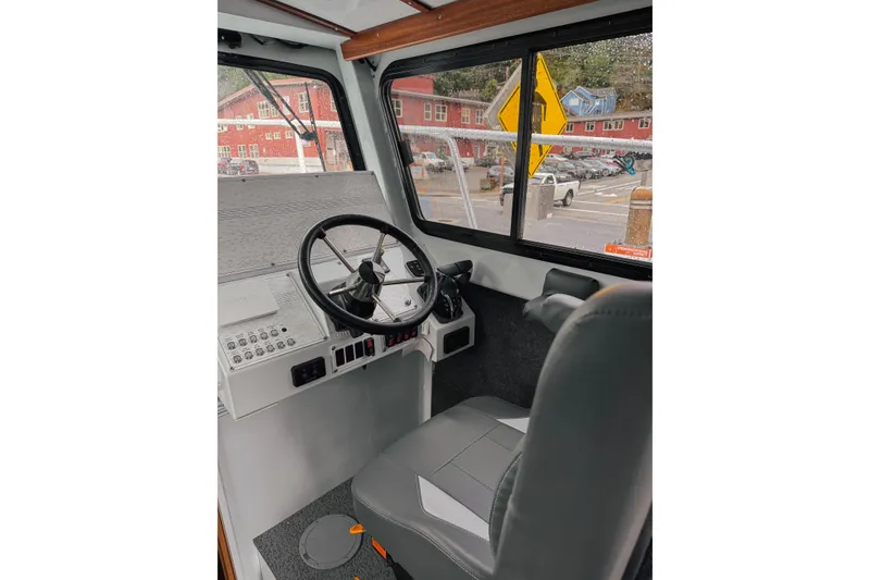 Slide: The Image of Interior of 2026 Hewescraft 290 Adventure boat, featuring steering wheel and control panel. - 6