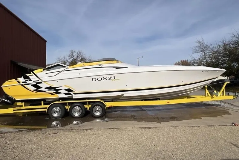 Slide: The Image of 2002 Donzi 38 Daytona powerboat on yellow trailer, featuring sleek design and vibrant graphics. - 2