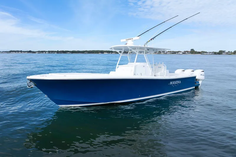 Slide: The Image of 2018 Regulator 34SS boat on calm water, featuring a sleek blue hull and fishing rods. - 2