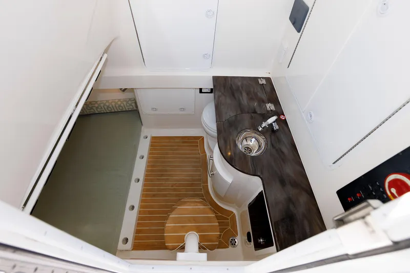 Slide: The Image of 2018 Regulator 34SS boat interior with sink, toilet, and wooden flooring. - 28