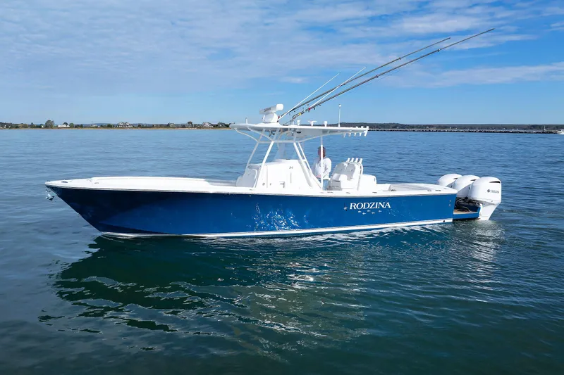 Slide: The Image of 2018 Regulator 34SS boat on calm water, blue hull, twin Yamaha engines. - 3