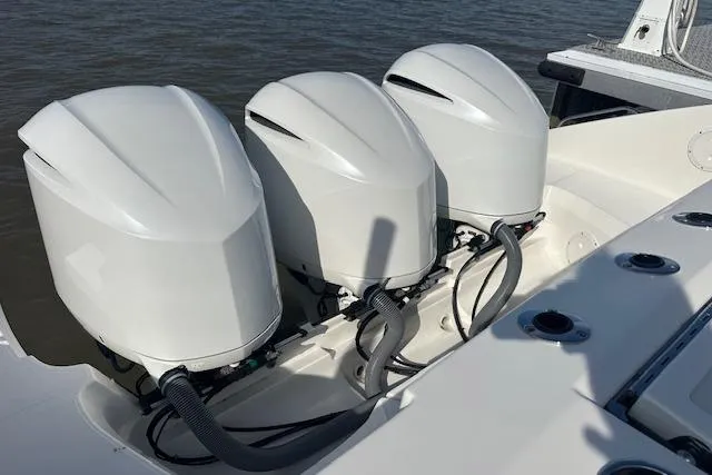 Slide: The Image of 2019 Pursuit DC 365 Dual Console with triple outboard engines on water. - 10