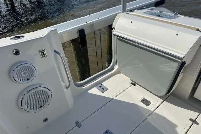 Slide: The Image of 2019 Pursuit DC 365 Dual Console boat interior with speakers and storage compartment. - 19