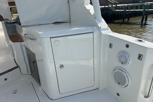 Slide: The Image of 2019 Pursuit DC 365 Dual Console boat interior with storage and speakers. - 20
