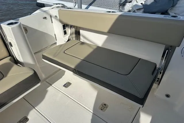 Slide: The Image of 2019 Pursuit DC 365 Dual Console boat interior with foldable seating and storage compartments. - 21