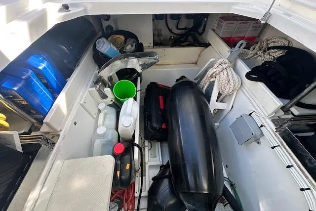 Slide: The Image of Storage compartment of 2019 Pursuit DC 365 Dual Console boat with various supplies. - 24