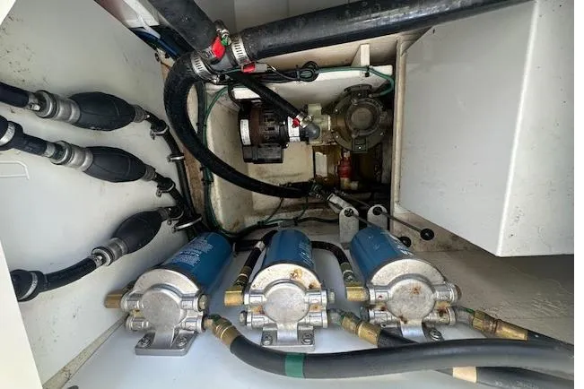 Slide: The Image of Engine compartment of a 2019 Pursuit DC 365 Dual Console boat, showcasing pumps and hoses. - 25