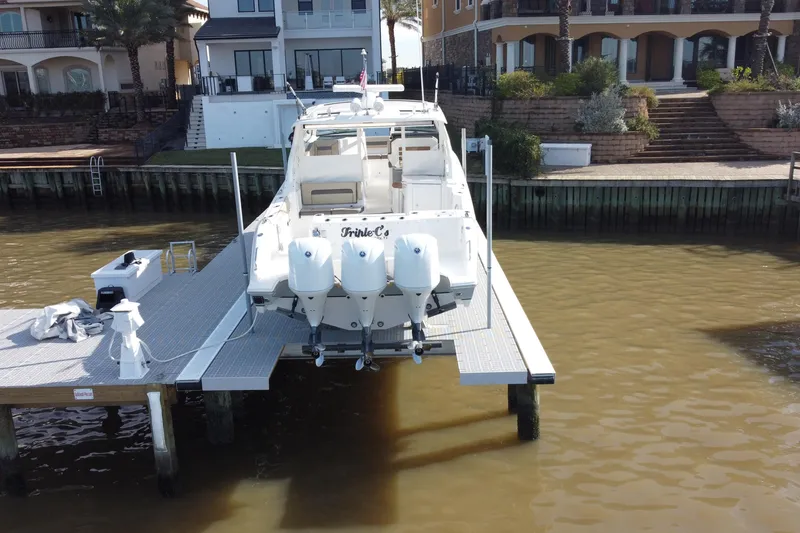 Slide: The Image of 2019 Pursuit DC 365 Dual Console boat docked near waterfront homes. - 5