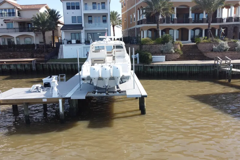 Slide: The Image of 2019 Pursuit DC 365 Dual Console boat docked near waterfront homes. - 6