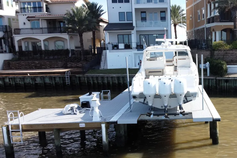 Slide: The Image of 2019 Pursuit DC 365 Dual Console boat docked near waterfront homes. - 7