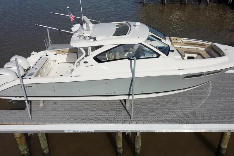 Slide: The Image of 2019 Pursuit DC 365 Dual Console boat docked on water. - 9