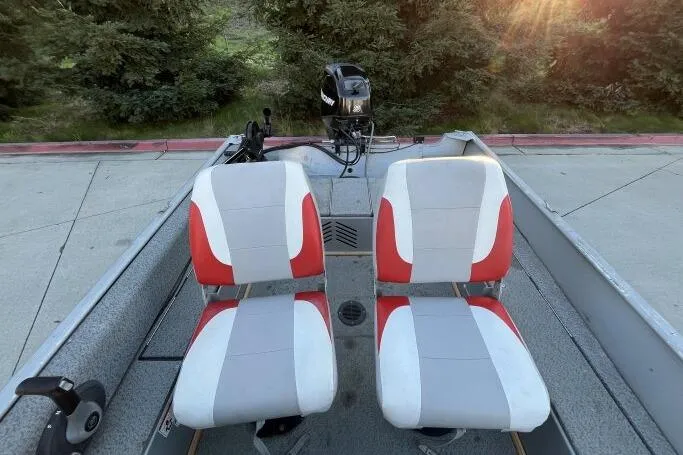 Slide: The Image of 2008 Tracker Super Guide V-14 SC boat with red and white seats, parked outdoors. - 10