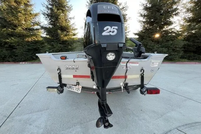 Slide: The Image of 2008 Tracker Super Guide V-14 SC boat with 25 HP engine, parked outdoors. - 16
