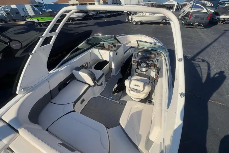 Slide: The Image of 2016 Chaparral 227 SSX boat interior with seating and steering wheel, parked outdoors. - 5