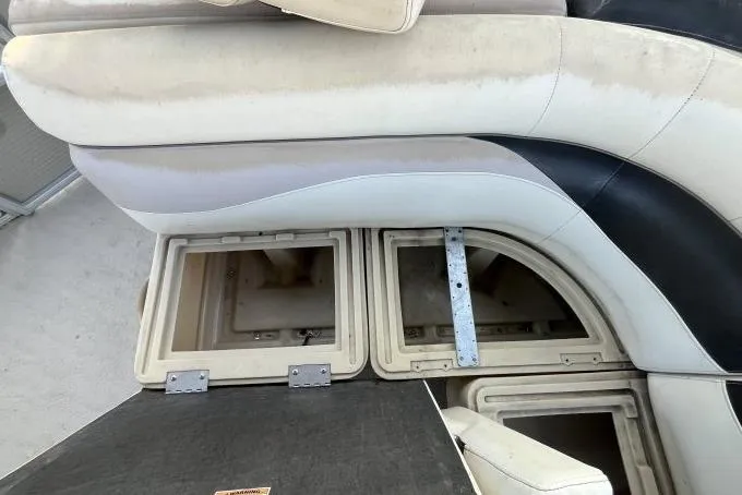 Slide: The Image of Open storage compartments in a 2013 Godfry Sweetwater boat with cushioned seating. - 14