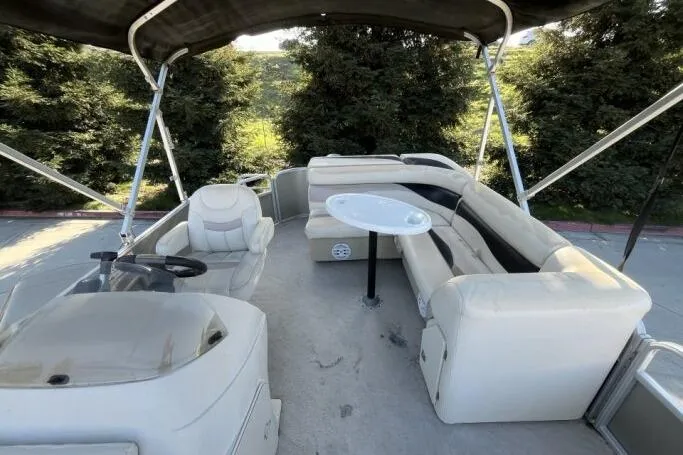 Slide: The Image of 2013 Godfry Sweetwater boat interior with seating, table, and steering console. - 15
